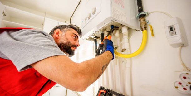 Middle-aged, bearded  man repair gas boiler with wrenches, Gas Heating Boiler Service At Home